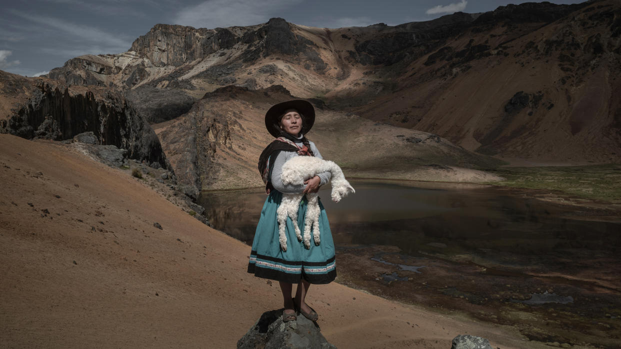  Alina Surquislla Gomez, a third-generation alpaquera (alpaca-farmer), cradles a baby alpaca on the way to her family’s summer pastures, in Oropesa, Peru. The climate crisis is forcing herders, many of whom are women, to search for new pastures, often in difficult terrain. 