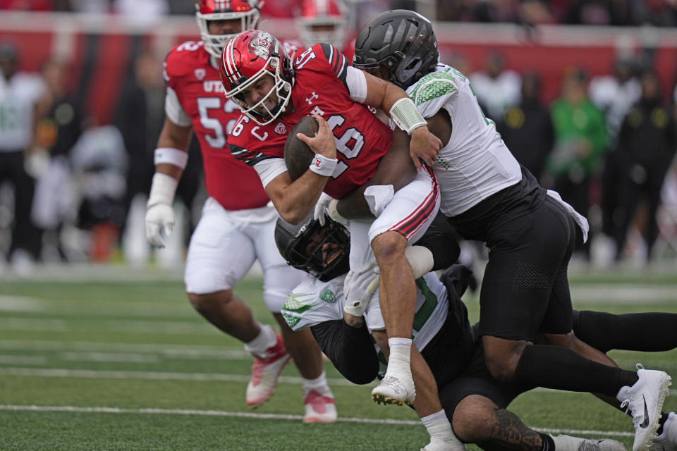 Oregon defensive end Jordan Burch, right, tackles Utah quarterback Bryson Barnes (16) during the first half of an NCAA college football game Saturday, Oct. 28, 2023, in Salt Lake City. (AP Photo/Rick Bowmer)