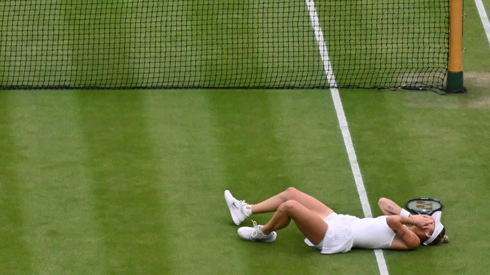 Vondroušová fell to the grass after securing a famous win. - Glyn Kirk/AFP/Getty Images