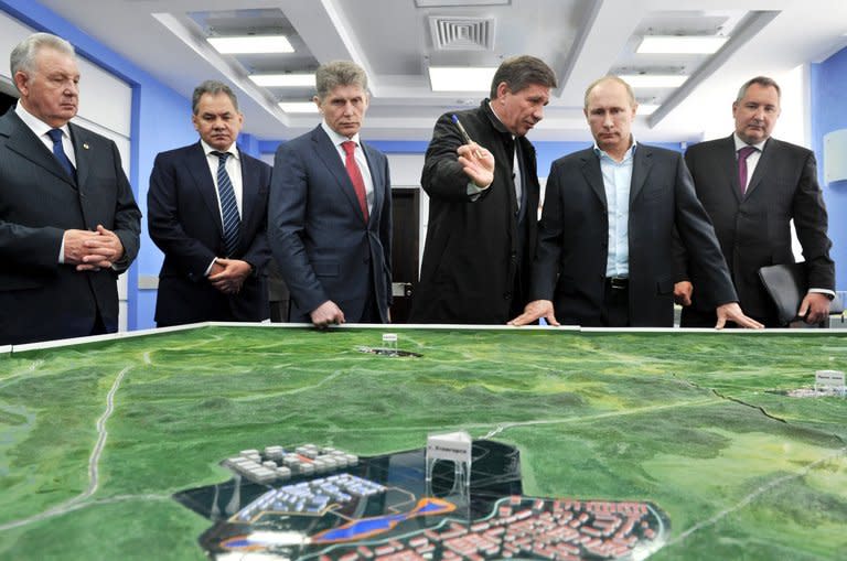 Vladimir Putin (2ndR) inspects a model of the Vosptochny cosmodrome in the Amur region, on April 12, 2013. The Russia president unveiled a new $50 billion drive for Russia to preserve its status as a top space power, including the construction of a brand new cosmodrome from where humans will fly to space by the end of the decade