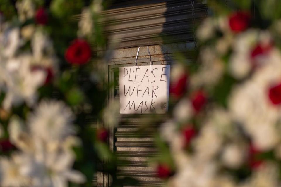 Signage requires masks at a business in the flower district in Skid Row reopening in time for Mother’s Day on May 8, 2020 in Los Angeles, California.