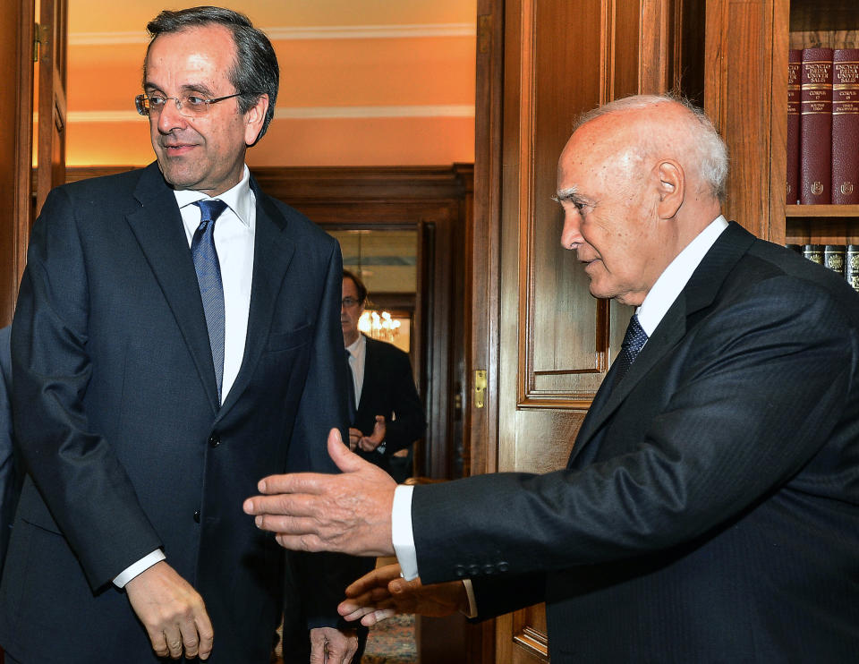 The head of Greece's conservative New Democracy party, Antonis Samaras, left, is welcomed by the President Carolos Papoulias in Athens on Wednesday June 20, 2012. Samaras was sworn in as prime minister Wednesday at the helm of a three-party coalition that will uphold the country’s international bailout commitments. The move ends a protracted political crisis that had cast grave doubt over the country’s future in Europe’s joint currency and threatened to plunge Europe deeper into a financial crisis with global repercussions. (AP Photo/Andreas Solaro,pool)