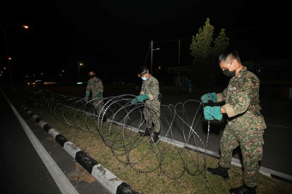 The largest cluster discovered today involved workers in a construction site in Ipoh. File picture shows Armed Forces personnel erecting barbed wire fencing in Medan Klebang Restu, Ipoh July 26, 2021. — Picture by Farhan Najib