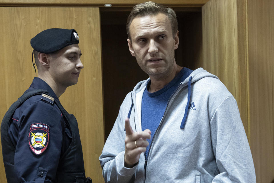 Russian opposition leader Alexei Navalny, right, gestures while speaking in a court room in Moscow, Russia, Monday, Aug. 27, 2018. A court in Moscow has sentenced Russian opposition leader Alexei Navalny to a month in jail for an unsanctioned protest rally. Navalny’s arrest outside his home on Saturday came as a surprise since police detained him over a protest rally held in January. (AP Photo/Pavel Golovkin)