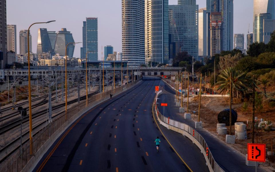 A man runs on a car-free highway, during the Jewish holiday of Yom Kippur, in Tel Aviv - AP