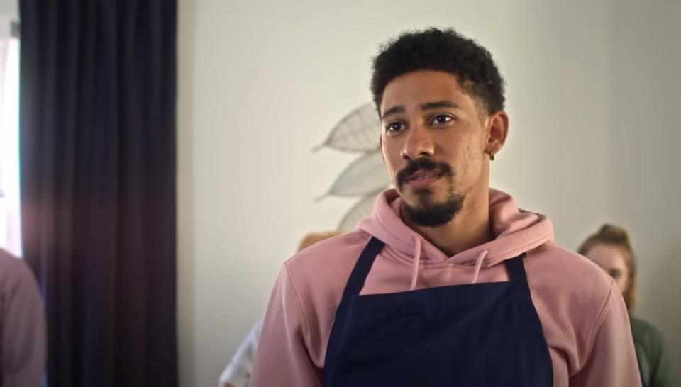 Keiynan Lonsdale wearing an apron in cooking class