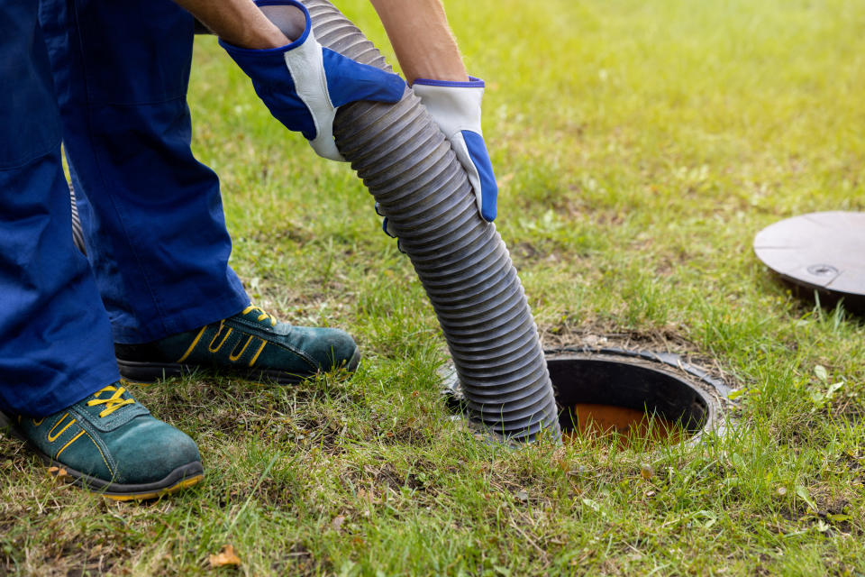 worker pumping out septic tank