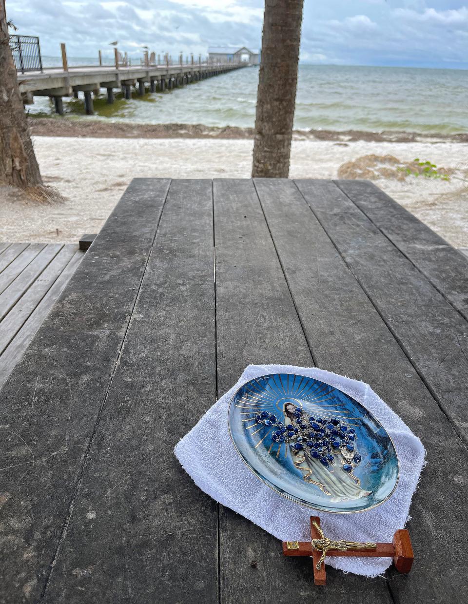 A prayer offering on a picnic table next to the historic Anna Maria Pier. Businesses and local residents of Anna Maria Island, board up and sandbag doorways preparing for Hurricane Ian on Tuesday September 27, 2022. 