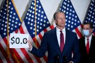 Senator Thune holds a sign while speaking at a news conference at the U.S. Capitol in Washington