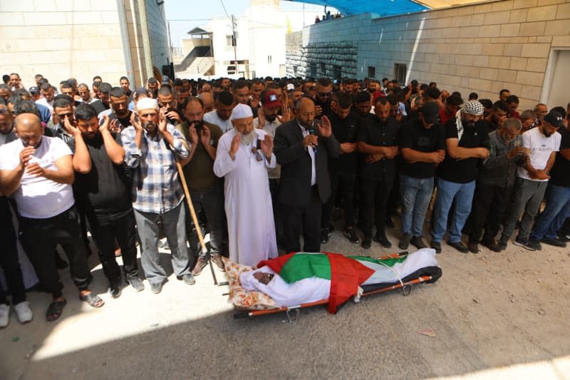 Palestinians perform a funeral prayer over the robed body of Khalil Salem Khalawi during his funeral in the village of Wadi Rahhal south of the city of Hebron in the occupied West Bank. Mamoun Wazwaz/APA Images via ZUMA Press Wire/dpa