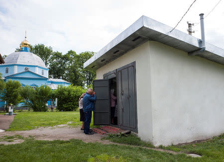 Faithfuls of the Ukrainian Orthodox Church of the Moscow Patriarchate attend a service at the priest's packed garage in the village of Ptycha, Ukraine May 13, 2018. Picture taken May 13, 2018. REUTERS/Gleb Garanich