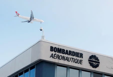 FILE PHOTO: A plane flies over a Bombardier plant in Montreal, Quebec, Canada on January 21, 2014. REUTERS/Christinne Muschi/File Photo