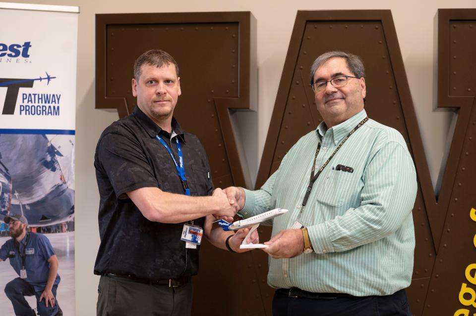 SkyWest Aircraft Maintenance Technician Michael LaFollette shakes hands with WMU College of Aviation Dean Raymond Thompson at Western Michigan University's College of Aviation in Battle Creek on Monday, Jan. 23, 2023.