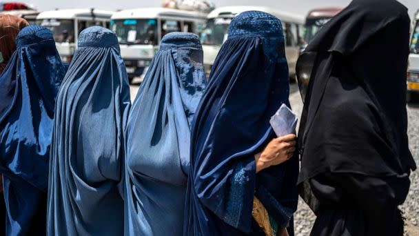 PHOTO: Afghan internally displaced refugee women stand in a queue to identify themselves and receive money as they return home to the east, at the United Nations High Commissioner for Refugees (UNHCR) camp in the outskirts of Kabul on July 28, 2022. (Wakil Kohsar/AFP via Getty Images )