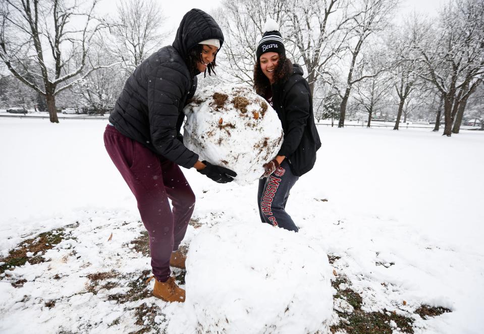 Missouri State student athletes Jade Masogayo (left) and Trinity White stack part of a snowman onto the other half in Phelps Grove Park on Monday, Feb.12, 2024.