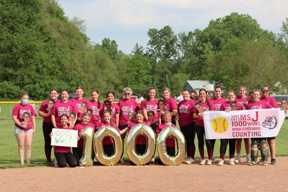 Morenci's softball team poses with signs and ballons for coach Kay Johnson's 1,000th win.