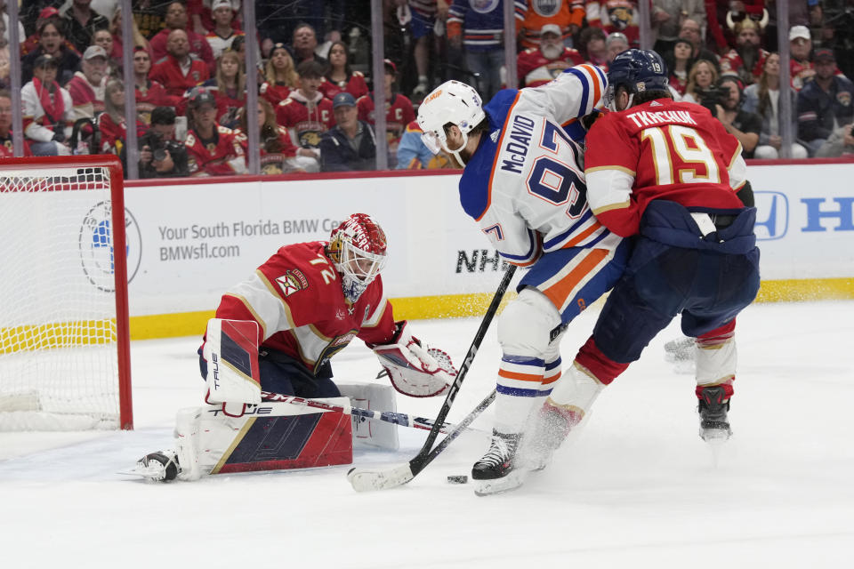 Florida Panthers goaltender Sergei Bobrovsky (72) and left wing Matthew Tkachuk (19) defend the net from a shot by Edmonton Oilers center Connor McDavid (97) during the third period of Game 2 of the NHL hockey Stanley Cup Finals, Monday, June 10, 2024, in Sunrise, Fla. (AP Photo/Wilfredo Lee)