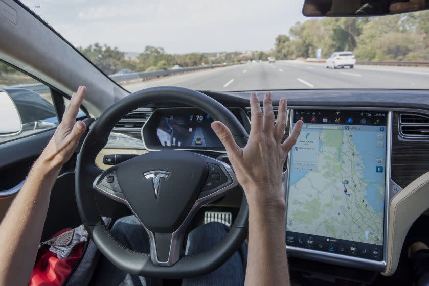 A member of the media test drives a Tesla Motors Inc. Model S car equipped with Autopilot in Palo Alto, California, U.S., on Wednesday, Oct. 14, 2015. Tesla Motors Inc. will begin rolling out the first version of its highly anticipated "autopilot" features to owners of its all-electric Model S sedan Thursday. Autopilot is a step toward the vision of autonomous or self-driving cars, and includes features like automatic lane changing and the ability of the Model S to parallel park for you. Photographer: David Paul Morris/Bloomberg via Getty Images