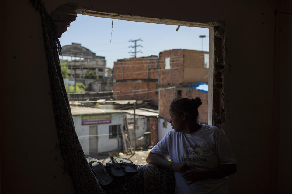 In this Jan. 9, 2014 photo, a resident looks from her window at the Favela do Metro slum near Maracana stadium where some homes have been demolished in Rio de Janeiro, Brazil. Residents in this slum were evicted from their homes two years ago for the area to be renovated for the 2014 World Cup and 2016 Olympics, but people reoccupied the homes and are fighting to stay. (AP Photo/Felipe Dana)