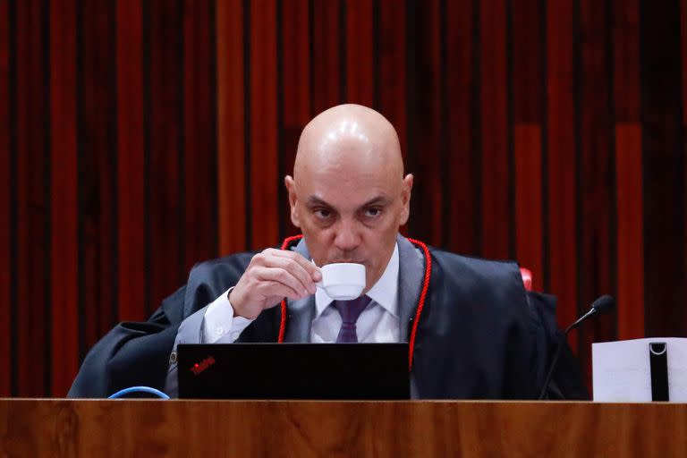 El presidente del Tribunal Superior Electoral, Alexandre de Moraes, bebe café durante el inicio del tercer día del juicio al expresidente brasileño Jair Bolsonaro, acusado de abuso de poder y desinformación, en Brasilia el 29 de junio de 2023. (Foto de Sergio Lima / AFP)