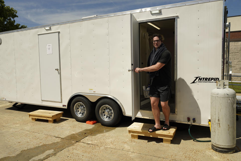 James Henry, a student athlete at Millsaps College exits one of the rented portable showers, at the midtown Jackson, Miss., school, Thursday, Sept. 1, 2022. The school rented them for the 200 students that remained on campus during the city's latest water crisis. (AP Photo/Rogelio V. Solis)