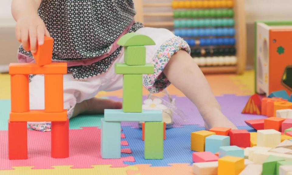 Baby girl playing toy block at home.