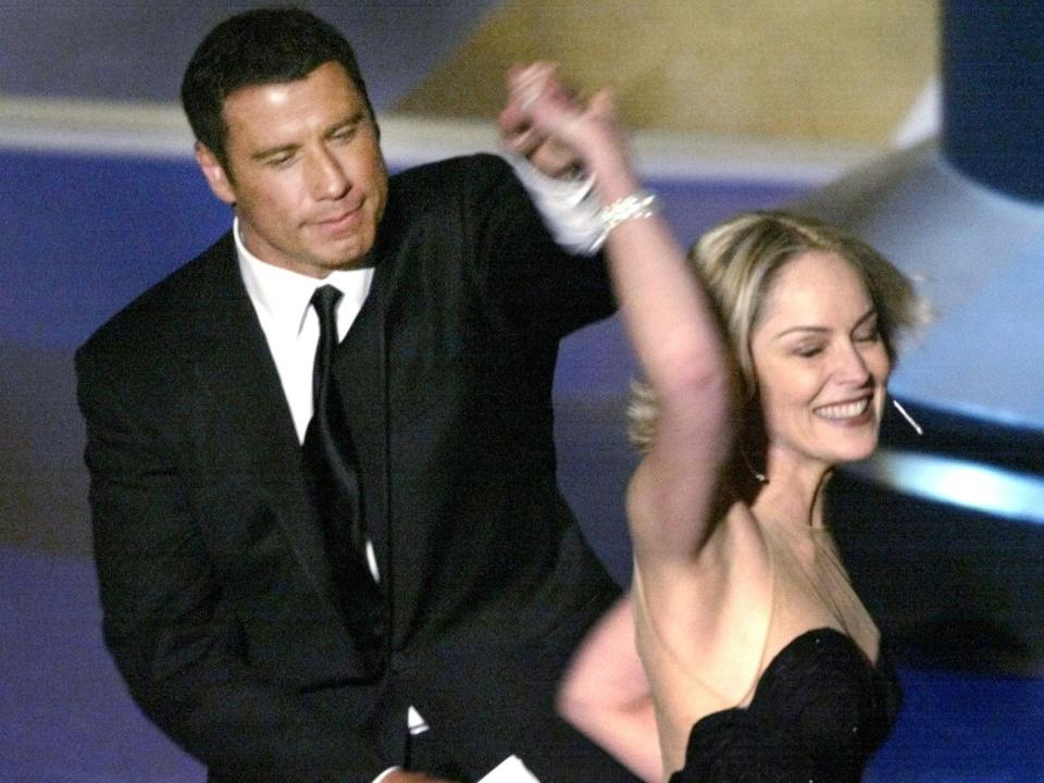 John Travolta (L) and Sharon Stone dance together during the 74th annual Academy Awards in Hollywood March 24, 2002. The two actors presented the Oscar for Best Foreign Film, which went to the film "No Man's Land". REUTERS/Gary Hershorn