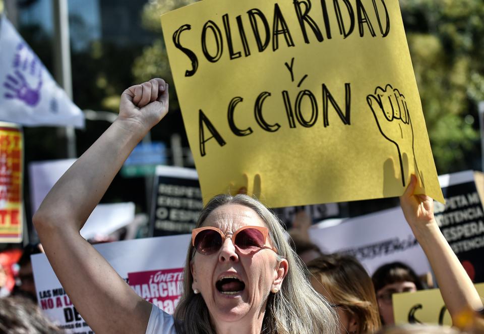 A woman holds a sign reading 'Solidarity and action' during the Women's March against President Donald Trump in Mexico City on Jan. 21, 2017.