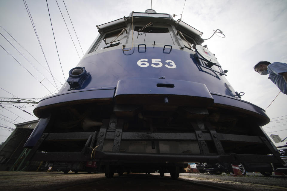 A tram which survived the Hiroshima atomic bomb is seen at a train maintenance facility of Hiroshima Electric Railway in Hiroshima, western Japan Monday, Aug. 3, 2020. It has been restored and repainted its original colors, will run on the street on Aug. 6 to commemorate the day of the U.S. first atomic bombing in the city. (AP Photo/Eugene Hoshiko)