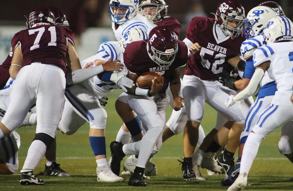 Beaver's Qualan Cain (5) gets wrapped up by South Park's Parker Cunningham (77) while sprinting through South Park's defensive line during the first half Friday night at Pat Tarquinio Field in Beaver, PA.
