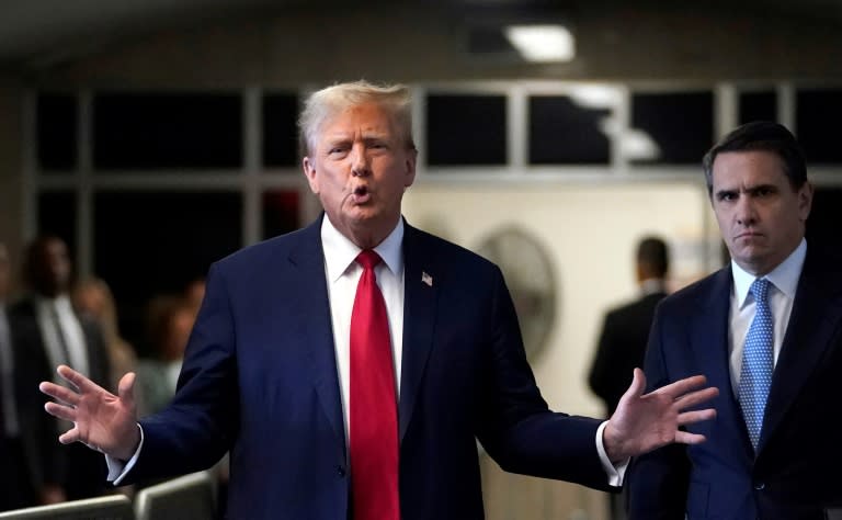 Former US President Donald Trump, with lawyer Todd Blanche (R), speaks to the press as he arrives at his trial for allegedly covering up hush money payments linked to extramarital affairs on April 23, 2024 (TIMOTHY A. CLARY)