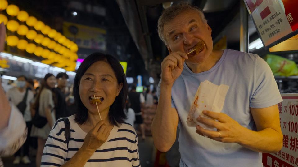 來到台灣，一定要吃吃看國民美食鹽酥雞，瞧瞧菲爾（右）大口咬下的模樣。（Netflix提供）