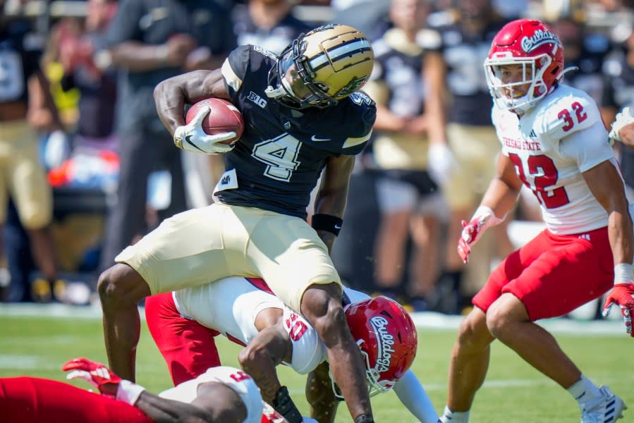 Purdue wide receiver Deion Burks (4) evades a tackle by Fresno State defensive back Kosi Agina (10) in route to a touchdown during the first half of an NCAA college football game in West Lafayette, Ind., Saturday, Sept. 2, 2023. (AP Photo/AJ Mast)