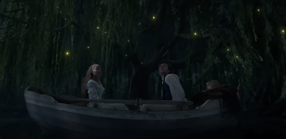 Ariel and Prince Eric sitting in a boat at night as they look up at glow worms