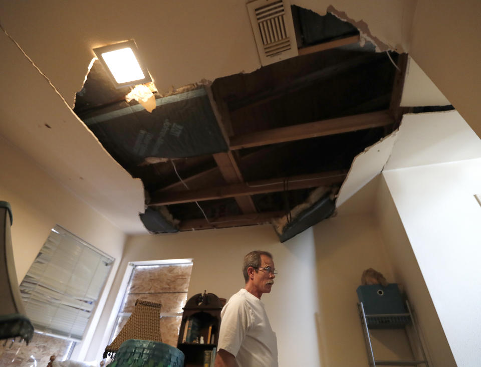 Kent Heap stands with a crumbling ceiling inside of his sister, Carol Goff's home, as people continued to sift through their damaged homes on Bridgeland Lane in Houston, Sunday, Jan. 26, 2020, after the Watson Grinding Manufacturing explosion early Friday morning. (Karen Warren/Houston Chronicle via AP)