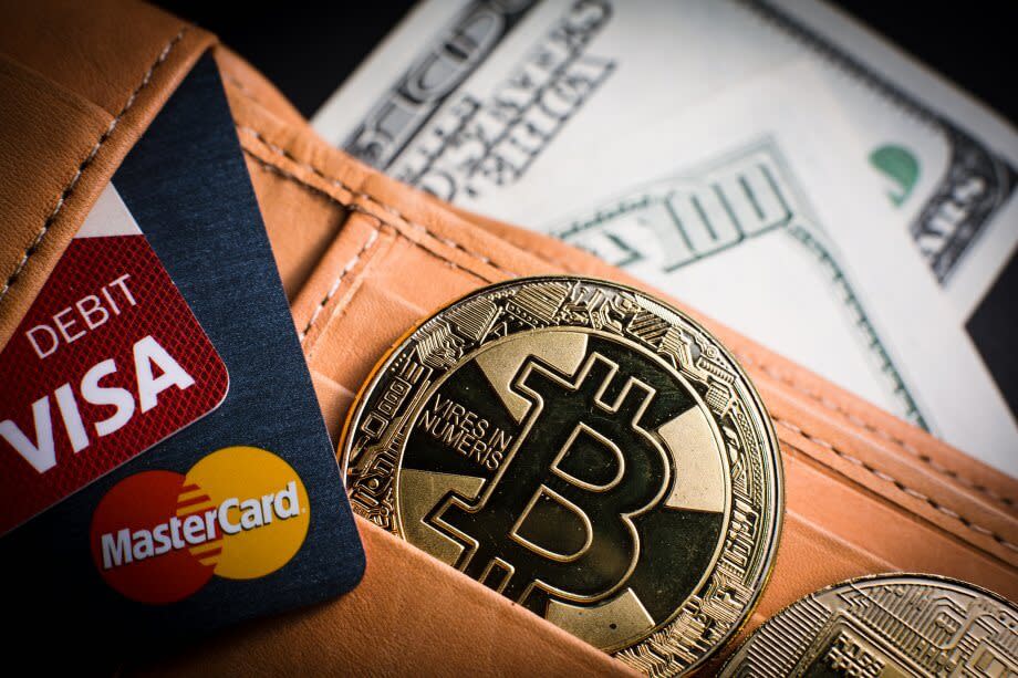 Portemonnaie mit Bitcoin-Münze und Kreditkarten von Visa und Mastercard