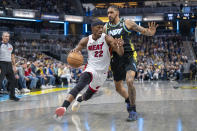 Miami Heat forward Jimmy Butler (22) makes a move around the defense of Indiana Pacers forward Obi Toppin, right, during the first half of an NBA basketball game in Indianapolis, Sunday, April 7, 2024. (AP Photo/Doug McSchooler)