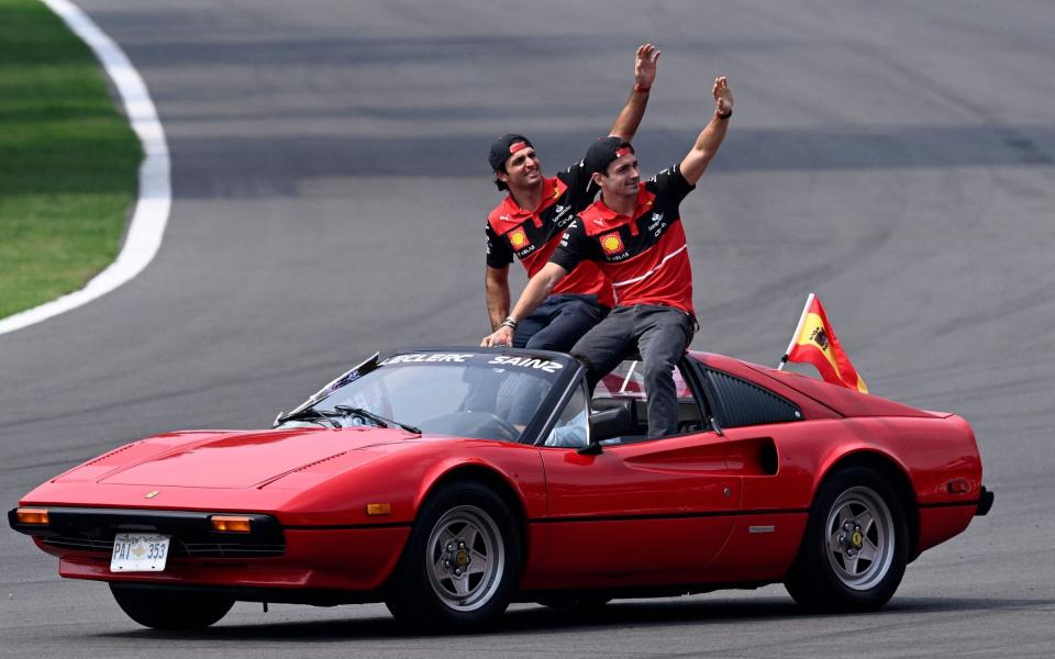 Ferrari's Monegasque driver Charles Leclerc (L) and his teammate Spanish driver Carlos Sainz Jr wave to fans during the drivers' parade, prior to the start of the Formula One Mexico Grand Prix at the Hermanos Rodriguez racetrack in Mexico City on October 30, 2022 - AFP