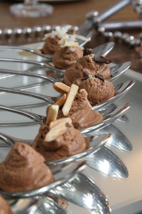 row of chocolate mousse plated on silver spoons