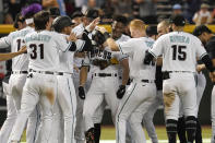 Arizona Diamondbacks mob Corbin Carroll, middle, after he drove in two runs with a single against the Colorado Rockies during the ninth inning of a baseball game Thursday, June 1, 2023, in Phoenix. Arizona won 5-4. (AP Photo/Darryl Webb)