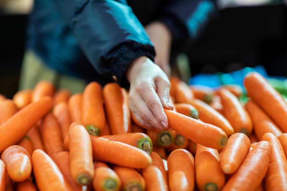 middle aged woman shopping for fresh organic groceries in supermarket