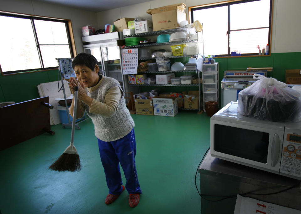 In this Monday, March 3, 2014 photo, Takako Sato, 62, a hearing impaired survivor of the March 11, 2011 tsunami, talks with Atsuko Takeshita, manager of Huck's House, a vocational center for the disabled, in Tanohata, Iwate Prefecture, northeastern Japan. The wait is just too much for Sato, who after nearly three years is fed up with the temporary housing. Hearing impaired, she waves her hands repeatedly to convey how her house was swept away, and holds them joined as if in prayer to express her frustrations. (AP Photo/Junji Kurokawa)