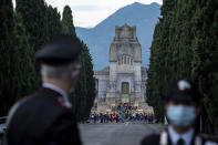 Carabinieri officers patrol the road leading to the Bergamo cemetery, Italy, Sunday, June 28, 2020. Italy bid farewell to its coronavirus dead on Sunday with a haunting Requiem concert performed at the entrance to the cemetery of Bergamo, the hardest-hit province in the onetime epicenter of the outbreak in Europe. President Sergio Mattarella was the guest of honor, and said his presence made clear that all of Italy was bowing down to honor Bergamo’s dead, “the thousands of men and women killed by a sickness that is still greatly unknown and continues to threaten the world.” (Claudio Furlan/LaPresse via AP)