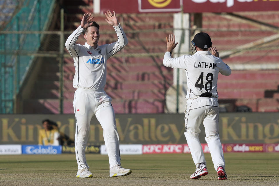 New Zealand's Michael Bracewell, left, celebrates with teammate Tom Latham after taking the wicket of Pakistan's Abdullah Shafique during the fourth day of first test cricket match between Pakistan and New Zealand, in Karachi, Pakistan, Thursday, Dec. 29, 2022. (AP Photo/Fareed Khan)