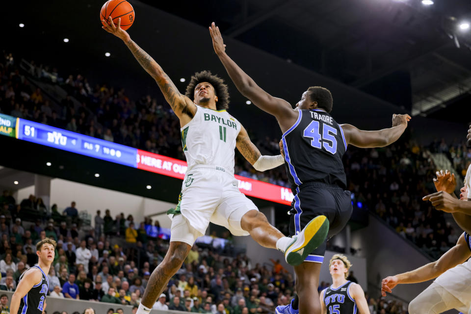 Baylor forward Jalen Bridges (11) scores while avoiding BYU forward Fousseyni Traore (45) during the second half of an NCAA college basketball game Tuesday, Jan. 9, 2024, in Waco, Texas. Baylor won 81-72. (AP Photo/Gareth Patterson)