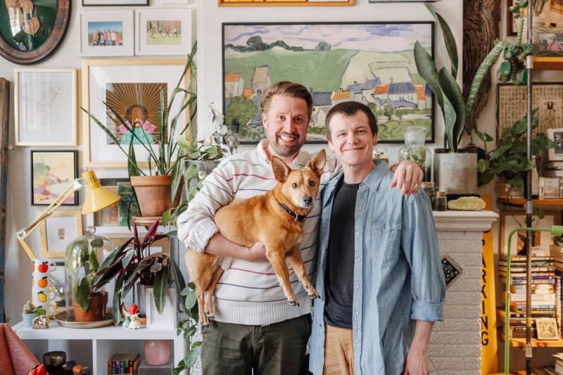 Dwellers pose with a dog in a living room.