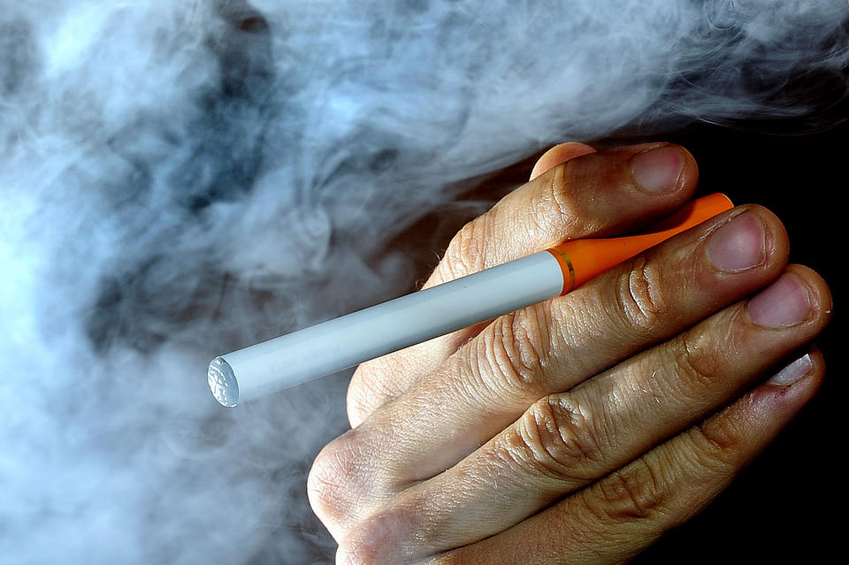 A person poses with an electronic cigarette, or e-cigarette, Wednesday June 12, 2013, after it was announced that Britain will start regulating electronic cigarettes as medicines, according to the country's top regulator, the Medicines and Healthcare Products Regulatory Agency. E-cigarettes are battery-operated products that turn nicotine into a vapor that is inhaled by the user, and the new regulations coming into force from 2016 will control products containing nicotine as medications, but normal cigarettes are exempt from the regulation. (AP Photo / Tim Ireland, PA) UNITED KINGDOM OUT - NO SALES - NO ARCHIVES