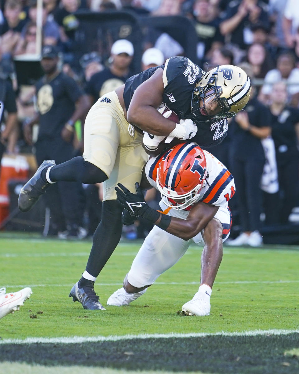 Purdue running back Dylan Downing (22) goes over Illinois defensive back Xavier Scott (14) on his way to a touchdown during the first half of an NCAA college football game in West Lafayette, Ind., Saturday, Sept. 30, 2023. (AP Photo/Michael Conroy)