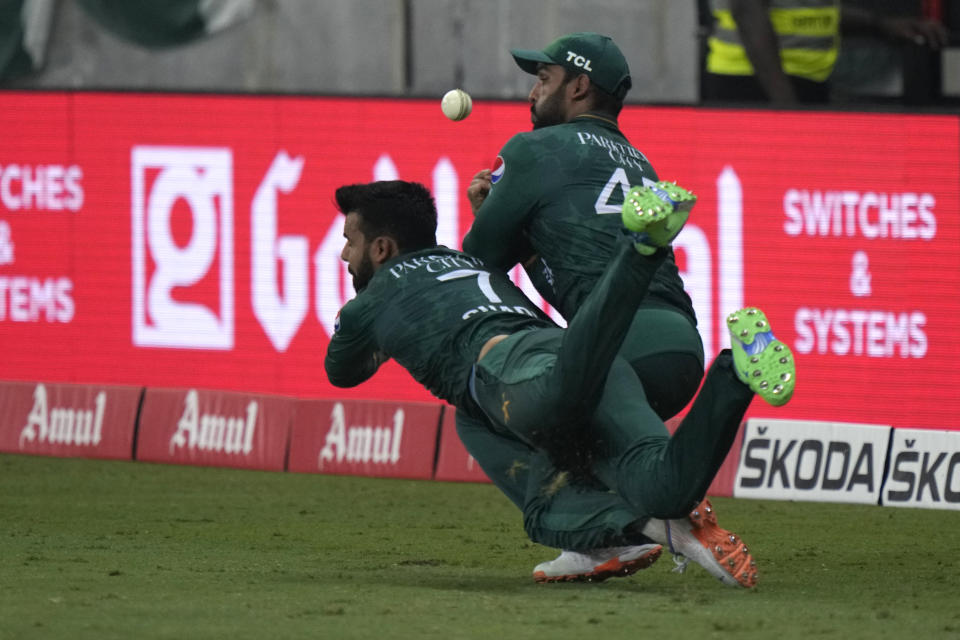 Pakistan's Shadab Khan, left, and Asif Ali collide in an unsuccessful attempt to take the catch of Sri Lanka's Bhanuka Rajapaksa during the T20 cricket Asia Cup final match between Pakistan and Sri Lanka, in Dubai, United Arab Emirates, Sunday, Sept. 11, 2022. (AP Photo/Anjum Naveed)