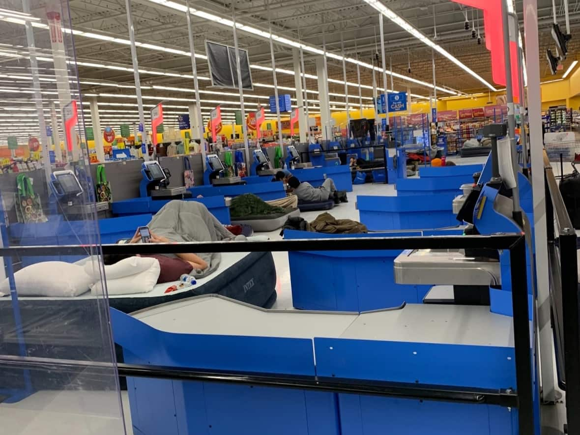 Stranded shoppers at a Walmart store in Chatham-Kent, in southwestern Ontario, sleep on air mattresses in the self-checkout area while waiting out a winter storm on Friday night. A total of 50 stranded customers and 48 staff spent the night. (Judy Lagasse - image credit)